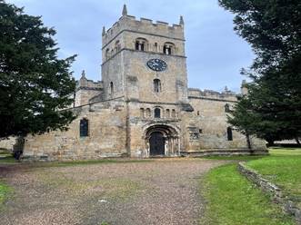 A stone building with a clock tower
Description automatically generated